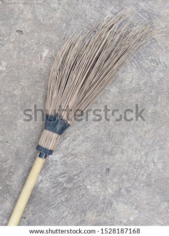 A broom with a sweeper for sweeping concrete on an old concrete background.
