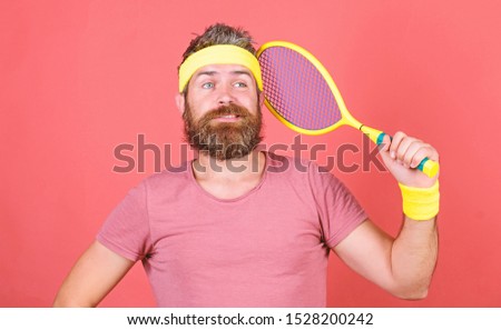 Play tennis for fun. Reach top again. Man bearded hipster wear sport outfit. Tennis player retro fashion. Tennis sport and entertainment. Athlete hipster hold tennis racket in hand red background.