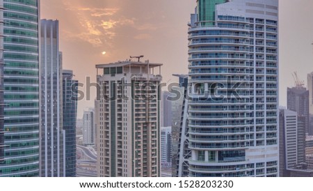 Sunset over residential and office buildings in Jumeirah lake towers district timelapse in Dubai. Aerial panoramic view from above with modern skyscrapers