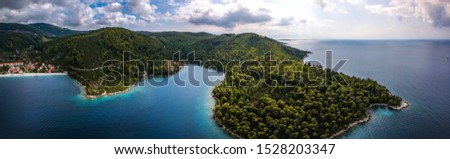 Ultra wide aerial panorama over Skopelos island Greece. Skopelos is the largest island of Sporades complex, covering 96 square km covered at 80% of its total extent from pinewoods damaskins and olives