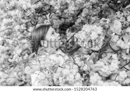 Sniffing flowers. Get rid of seasonal allergy. Girl enjoying floral aroma. Pollen allergy concept. Kid on pink flowers sakura tree background. Allergy remedy. Child enjoy life without allergy.