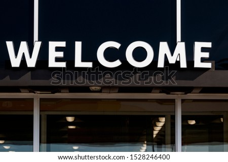 Welcome sign banner above business entrance