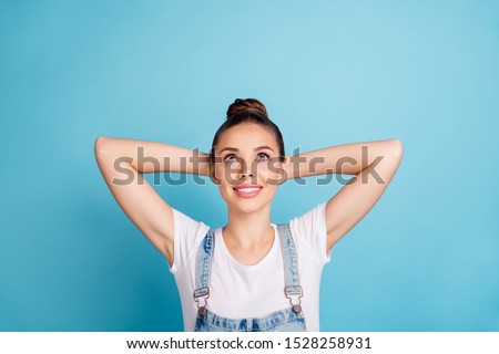 Top above angle photo of charming millennial lie look up wearing white t-shirt denim jeans overalls isolated over blue background
