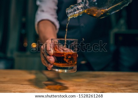 Barman pouring whiskey whiskey glass beautiful night Royalty-Free Stock Photo #1528261268