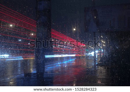 
View of the night road through wet glass