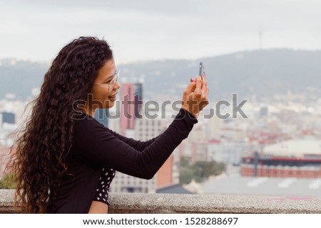 Attractive woman tourist taking a selfie, cityscape on the background