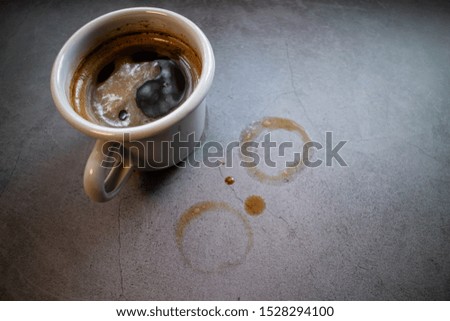 Cup of spresso coffee on concrete background with coffee spots.