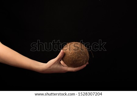 Coconut in hand. Coconut isolated on black background. Full depth of field. Macro Photo food fruit coconut. Texture tropical fruit coconut nut. Image fruit coconuts.