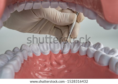 mouth view from inside with dentist hand with gloves and dentist tools
