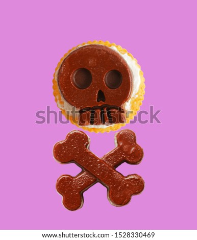 Salty cracker with cream cheese and chocolate in the shape of a skull on purple background.