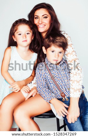 young mother with two children on white background, happy smiling family inside, lifestyle real people concept