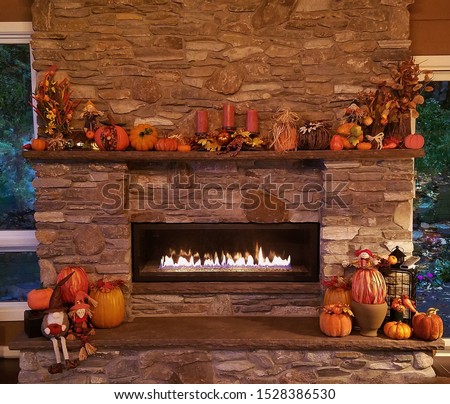 Warm and Cozy Large, Rustic Stone Fireplace with Surrounding Pumpkins and Autumn Decor; Cozy Home, Rustic Decor, Holiday Ideas Royalty-Free Stock Photo #1528386530