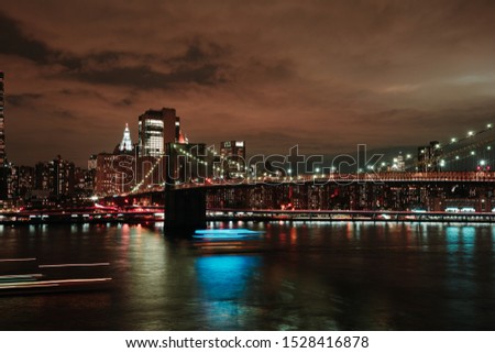 Night cityscape of Manhattan from the east side with the Brooklyn bridge in the foreground.