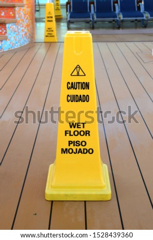 Yellow Caution Wet Floor safety pylon on a cruise ship