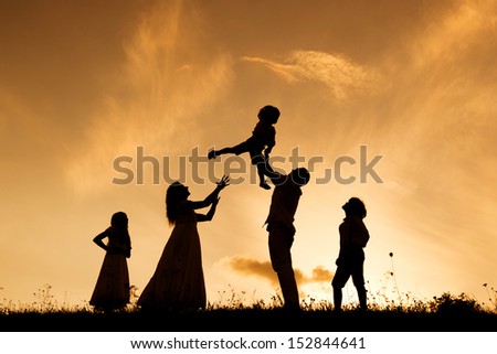 Silhouettes of happy parents having fun with their children