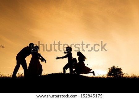Silhouettes of happy parents having fun with their children