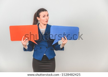 Young female teacher raising up two speech bubbles, looking at the camera as if presenting something really important.