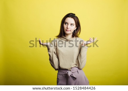 Image of happy young girl standing isolated over yellow background. Girl