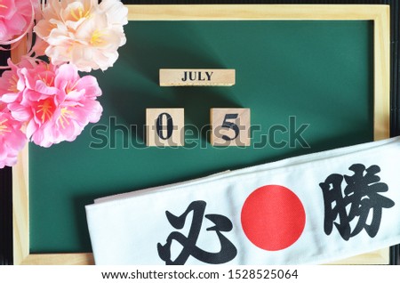 Japanese Cover, Date design with The headband written victory in japan font, and sakura flower on the wood green board, July 5.