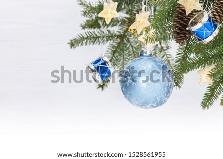 christmas tree branch decorated with ball, glowing star lights and decorative drum toys. festive winter holidays background