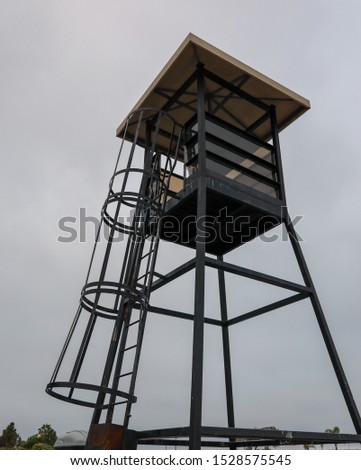 An observation tower with safety gate on ladder to view full 360 degree range for events or guarding. Lookout tower.
