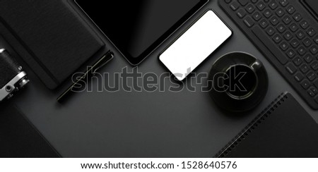 Overhead shot of dark modern workspace with copy space, blank screen smartphone, keyboard and office supplies on grey background 