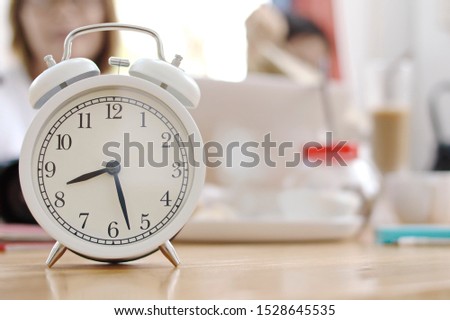 Alarm clock placed on the desk There is a blurry background. With copy spaces
