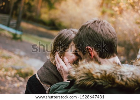 Happy young couple in love friends dressed in casual style walking together on nature park forest in the cold season, family advenure travel