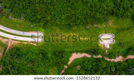 Aerial view of wildlife overpass over highway,  new road with tunnel in green summer mountains. Royalty-Free Stock Photo #1528652132