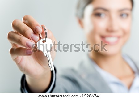 Photo of happy womanâ??s hand holding new key and pointing it at camera