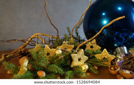 blue Christmas ball on a background of decor from fir branches and gold stars