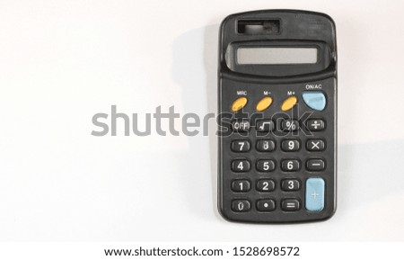 Old plastic calculator with different color buttons on a light background