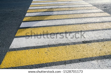 Detail of a yellow crosswalk on the road.