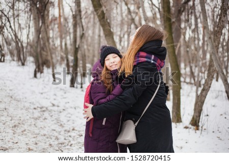 Mom hugs daughter, walk in the Park in winter, winter clothes