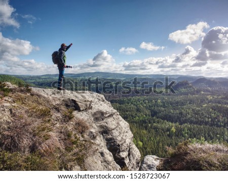 Travel photographer on mountain summit works. Man like to travel and photography taking pictures of moments during autumn 