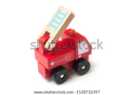 Closeup of miniature toy, wooden fire truck on white background