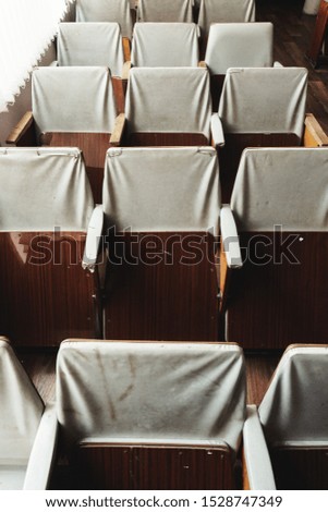old rows of seats in the hall for a large number of visitors