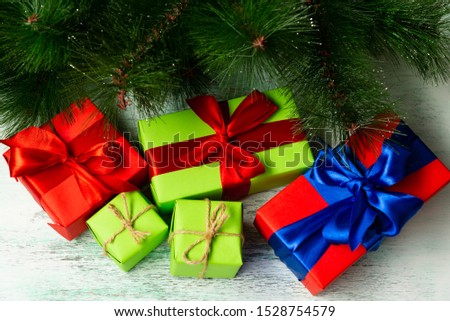 Gift boxes on a wooden light background near fir branches. Christmas composition