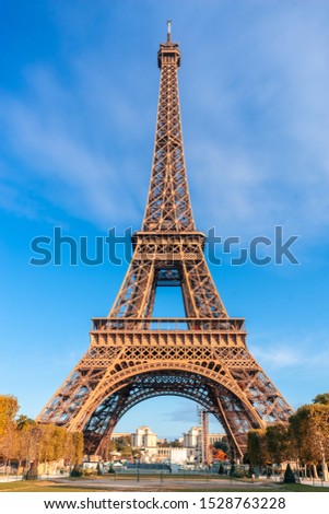 Eiffel Tower on blue sky background in autumn day. Colorful trees around. Paris Best Destinations. Travel in Europe Concept. Landmark, Sightseeing, Holidays and vacation in France. Vertical photo.