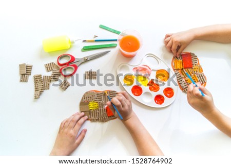 Craft orange pumpkin from cardboard. Children's hands creativity. Glue paper and color. Craftsmanship kindergarten school diy