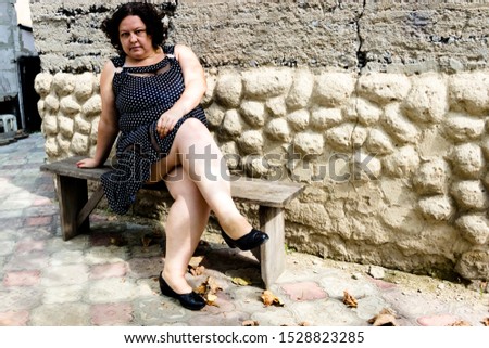 pictured in the photo owerweight woman in a black sundress white polka dots
