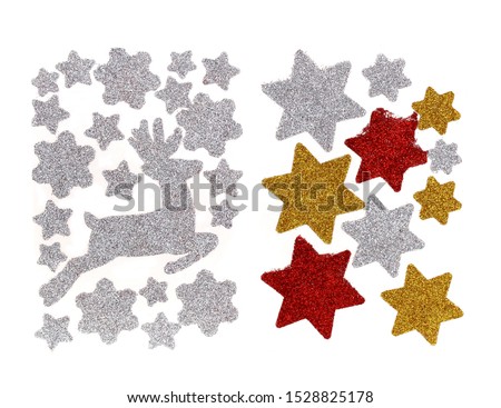 Set of glitter Christmas stickers isolated on a white background. They are white, gold and red stars and running Christmas reindeer. We can decorate gifts or Christmas cards