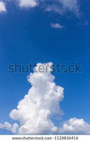 Shade of blue sky with floating fluffy white clouds.