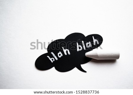 Black cloud speech with Blah-blah words and a white chalk near it on white background. The concept of communications