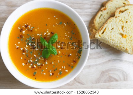 Closeup photo of seasonal autumn pumpkin soup and homemade pumpkin crunch bread 