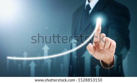 Man standing and pointing hand with Arrow and Line Visual Graphic on Light of Len flare and Boke blue background. COPY SPACE. Business Concept : Market Uptrend.