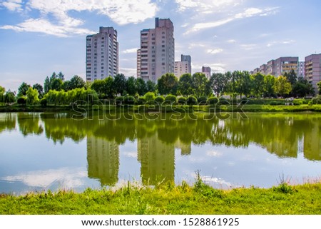 Modern high-rise residential buildings on the lake. Reflection in the water on a bright sunny day.