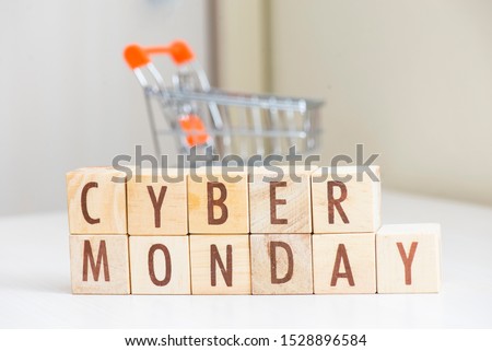 Wooden cube block cyber monday word on table with mini shopping cart