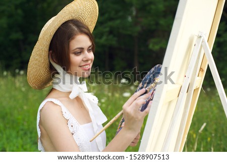 young woman with beautiful smile young easel in hat