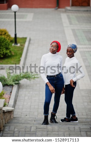 Two young modern fashionable, attractive, tall and slim african muslim womans in hijab or turban head scarf posed together.